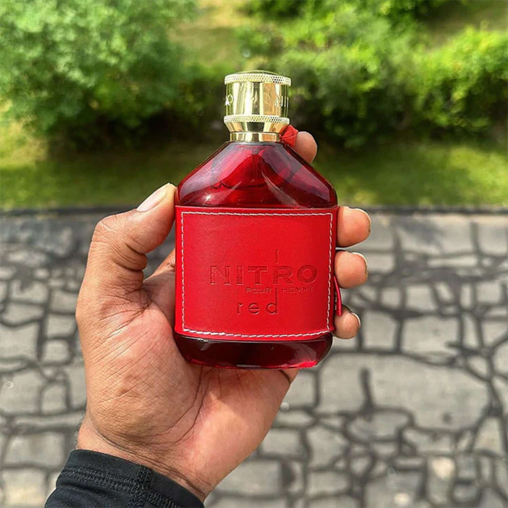 Frasco de Nitro Red Dumont EDP 100ML en una mano, fragancia aromática frutal para hombres.