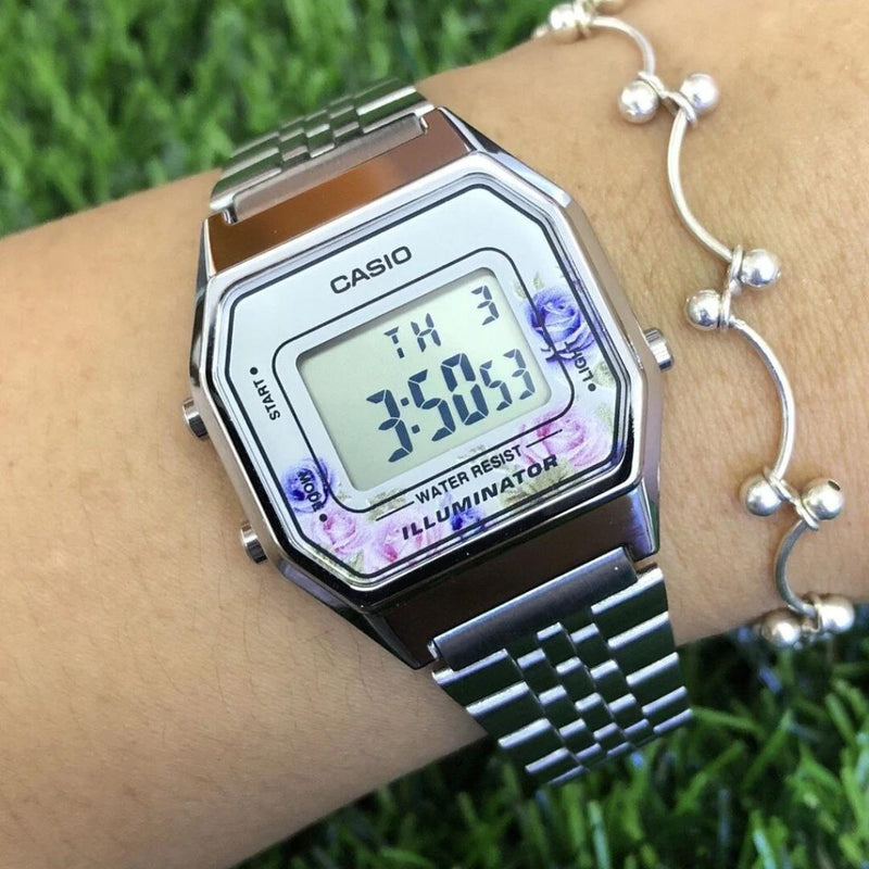 Vista lateral del Reloj Casio LA680WA-4C con bisel floral y correa de acero