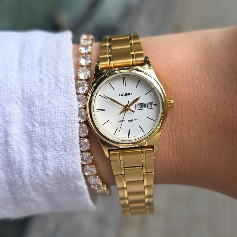 Reloj Casio LTP-V006G-7B dorado con esfera blanca para mujer puesto en muñeca.