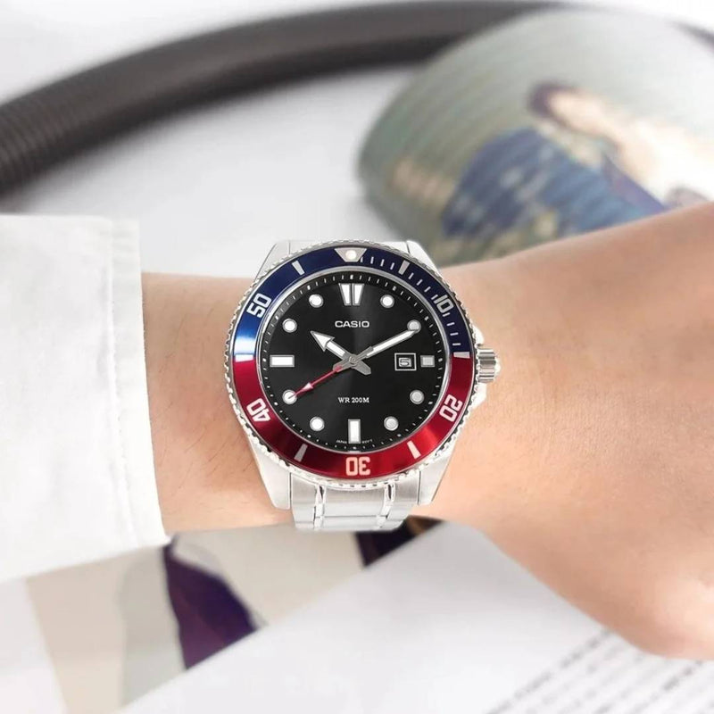 Detalle de la esfera negra y bisel bicolor del Reloj Casio MDV-107D-1A3, puesta en mano.