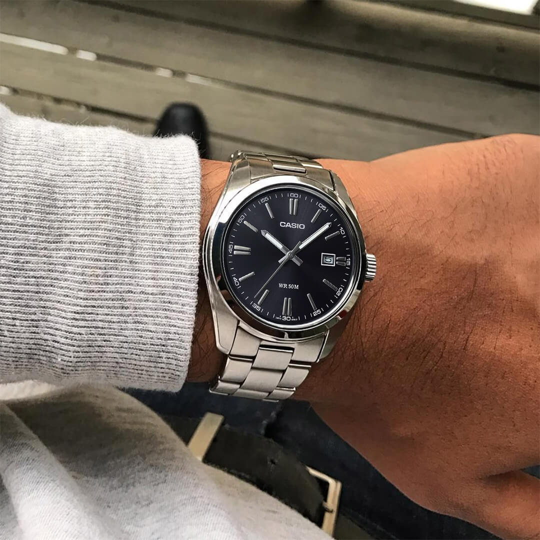 Reloj Casio MTP-1302D-1A1 para hombre de acero plateado con esfera negra en la muñeca.