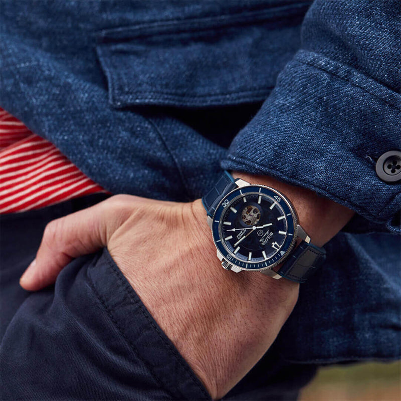 Reloj Bulova 96A291 azul y plateado en la muñeca de un hombre, estilo moderno con correa de silicona.